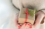 Frauenhände halten kleines Weihnachtsgeschenk