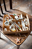 Christmas baubles in box on wooden chair