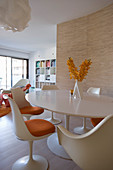 Round, white, classic Tulip table and matching chairs in dining area