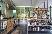 Island counter with stainless steel shelves below in open-plan kitchen