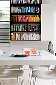 View of bookcase across white dining table