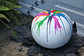 Handcrafted Halloween decoration: pumpkin painted white with colourful melted wax
