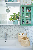 Baskets on sink below shelves and wall-mounted cabinet in bathroom