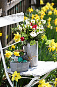 Natural spring bouquet on garden chair in bed of narcissus