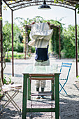 Frau deckt Holztisch im Garten