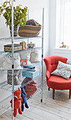 Modern metal shelves next to tomato-red armchair in corner