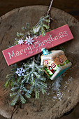 Christmas-tree decorations, fir branch and festive greeting