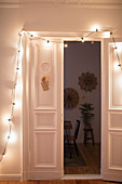 DIY-Adventskalender und Lichterkette an weißer Tür