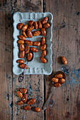 Caramelised nuts on blue plate and wooden table