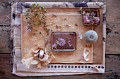 Getrocknete Knoblauchblüte, Schnittlauchblüte, Kerze und Knoblauch als Tischdekoration