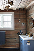 Blue sink unit in bathroom of log cabin