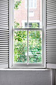 Spruch auf einem Fenster mit weißen Fensterläden