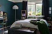 Mystical colour scheme in bedroom with deep teal walls