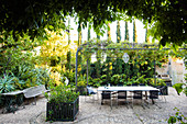 Long table on the terrace with pergola in the summer courtyard