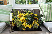 Vase of sunflowers in sunken niche in masonry bench
