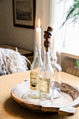 Stoppers and candles in vintage bottles on wooden tray