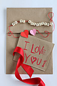 Love note on craft paper and string of lettered beads