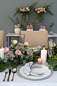 Festlich gedeckter Tisch mit üppiger Blumengirlande als Centerpiece