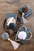 Gifts wrapped in black paper and decorated with pompoms, tassels and beaded heart