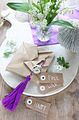 Hand-crafted Easter decorations in natural shades and purple on chopping board