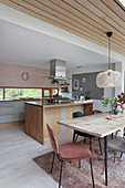Dining table and chairs next to kitchen counter in open-plan interior