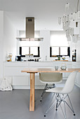 Zettel'z lamp above dining table in front of white, open-plan kitchen