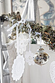 Lace doily and Christmas decoration on branch covered with moss and lichen