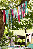 Garland handmade from colourful strips of fabric in garden