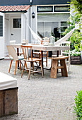 Rustic wooden table and chairs on paved terrace