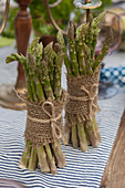 Bunches of green asparagus tied with hessian and string decorating table