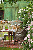 Table and chairs on rug on lawn in summery garden