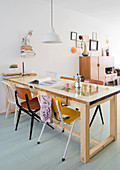 Dining table and various chairs in open-plan interior with retro ambience