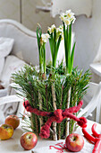 Daffodils in a pot wrapped with pine branches, small sticks and felt wool
