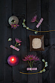 Decorative elements with flowers and rice bowl on a dark wooden table