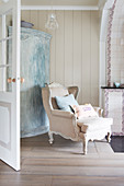 Baroque armchair in front of a shabby chic corner armoire