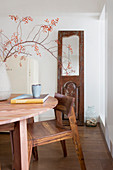 Old door with mirror in front of table and wooden chair in a dining room