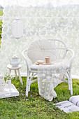 Cozy rattan armchair in front of a white curtain in a yard