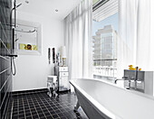 Badezimmer mit freistehender Badewanne und Panoramafenster