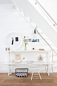Ornaments on white console table below stairs