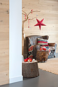 Vintage Ledersessel und Baumstämme als Beistelltische in weihnachtlich dekoriertem Zimmer