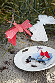 Homemade butterflies from doilies and a plate of mussels in the sand