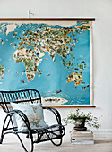 Schwarzer Rattanstuhl vor einer Weltkarte im Vintage-Stil