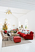 Living room with a red couch and armchairs in a restored mission style house