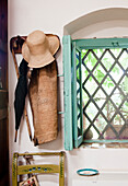 Garderobe neben Fenster mit türkisblauen Rahmen und Gitter in mediterranem Raum