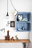 Blue wooden crates as a wall shelf above a table in a children's room