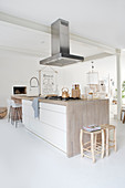 Kitchen island, ceiling-mounted hood in open plan living space