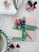 An envelope with a mint green ribbon and columbines