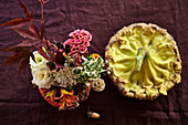 Herbstlicher Strauß in ausgehöhltem Kürbis und getrocknete Blüte