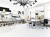 Schreibtisch und Designerleuchte im Atelier in Schwarz-Weiß