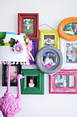 Family photos in colourful wooden frames on the wall